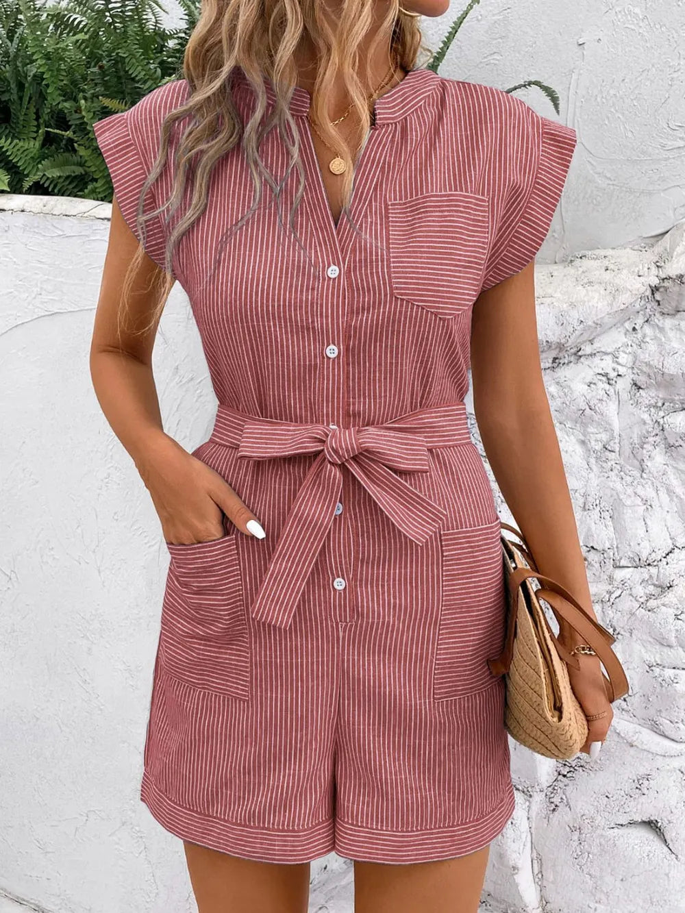 Striped notched tie-waist romper in dusty pink, front view with button placket and waist bow