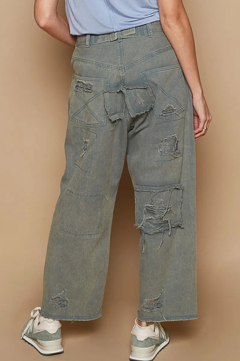 Washed denim wide-leg pants with distressed knee patches and raw frayed hem