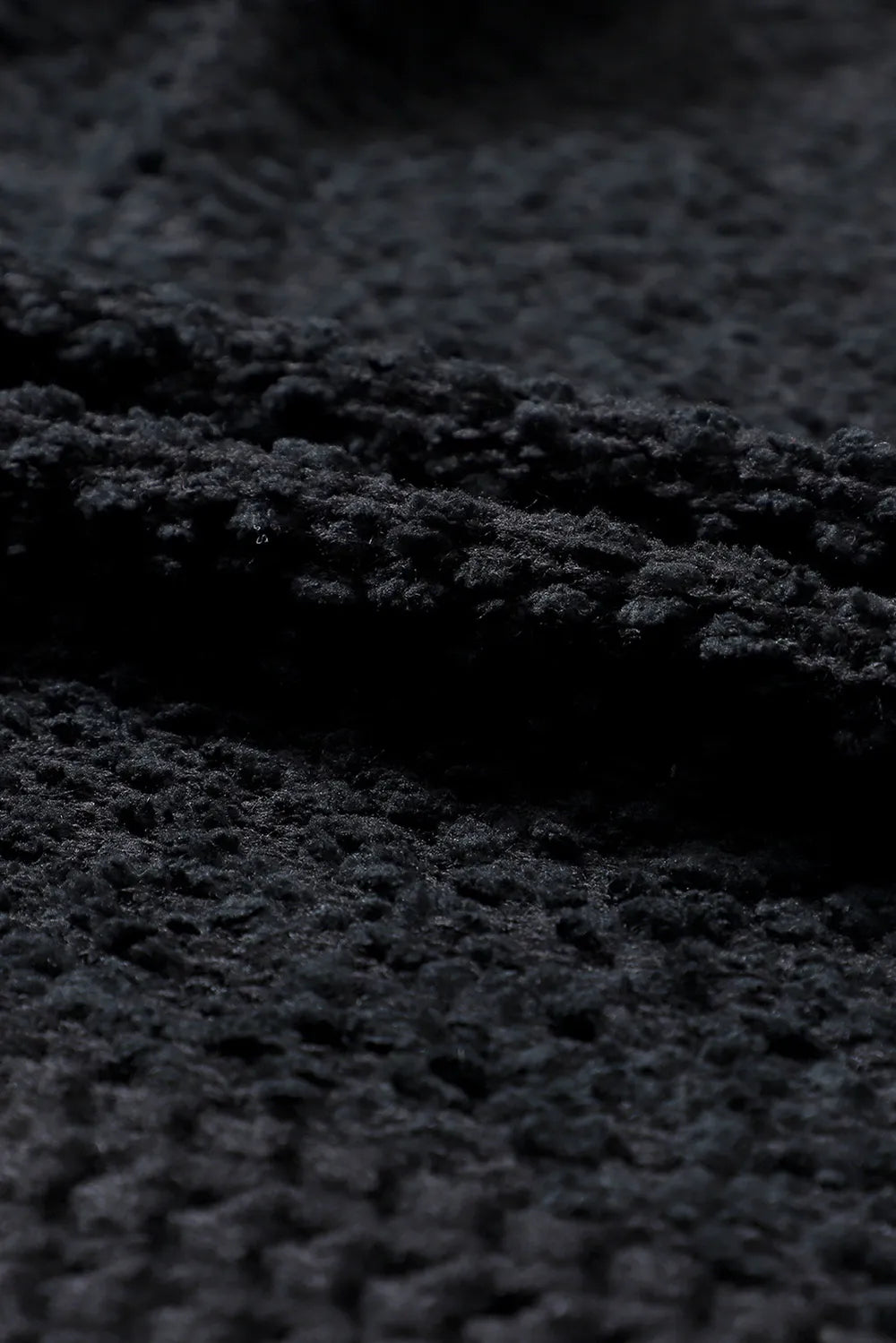 Black textured knit fabric with raised looped pattern surface