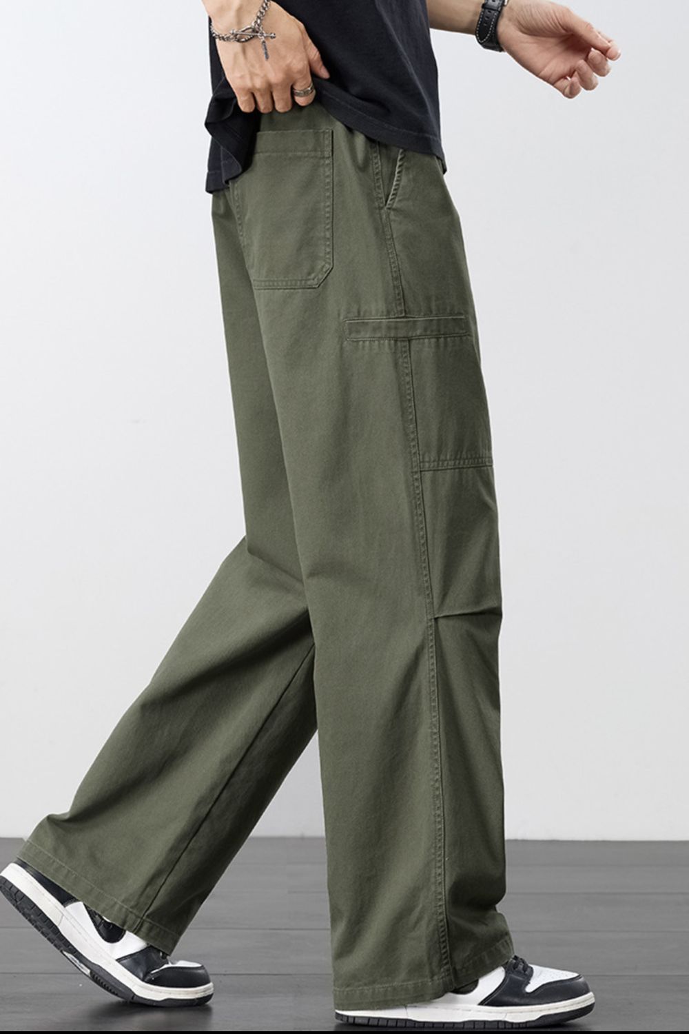 Dark olive cargo pants with drawstring waist and oversized side pockets, wide leg.