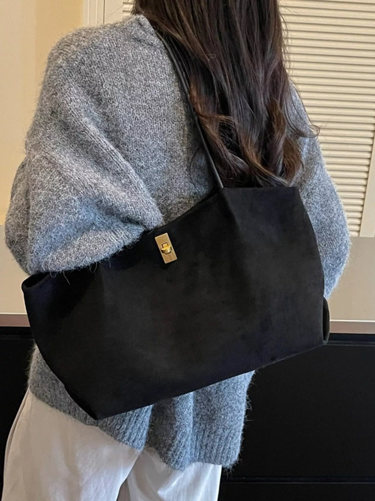 Black suede medium tote bag with gold turn-lock clasp and top handles