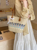 Woven straw shoulder bag with blue and light-blue lattice panel, brown leather handles