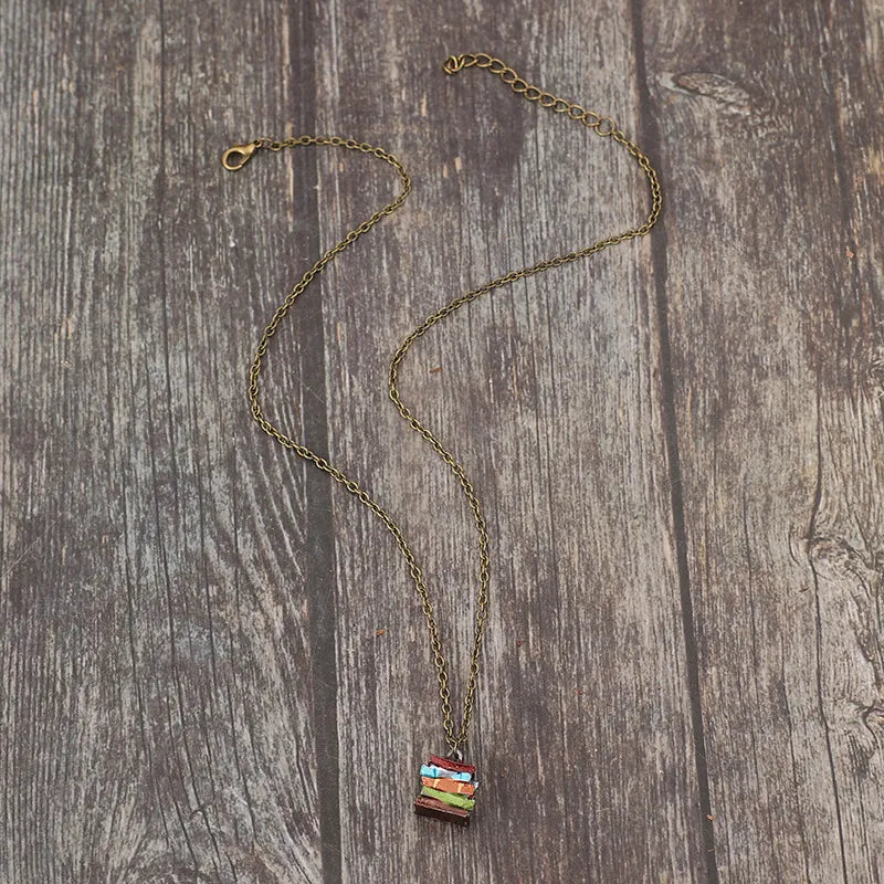 Gold-tone pendant necklace with hanging multicolor stacked book charm