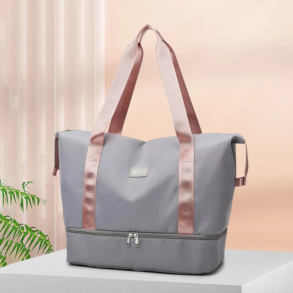 Gray nylon duffel bag with rose-colored handles and front zipper pocket