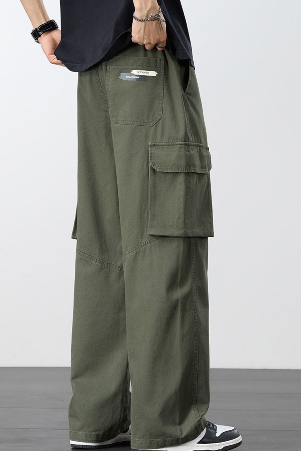 Men's loose cargo pants in army green with drawstring, elastic waist, and cargo flap pockets