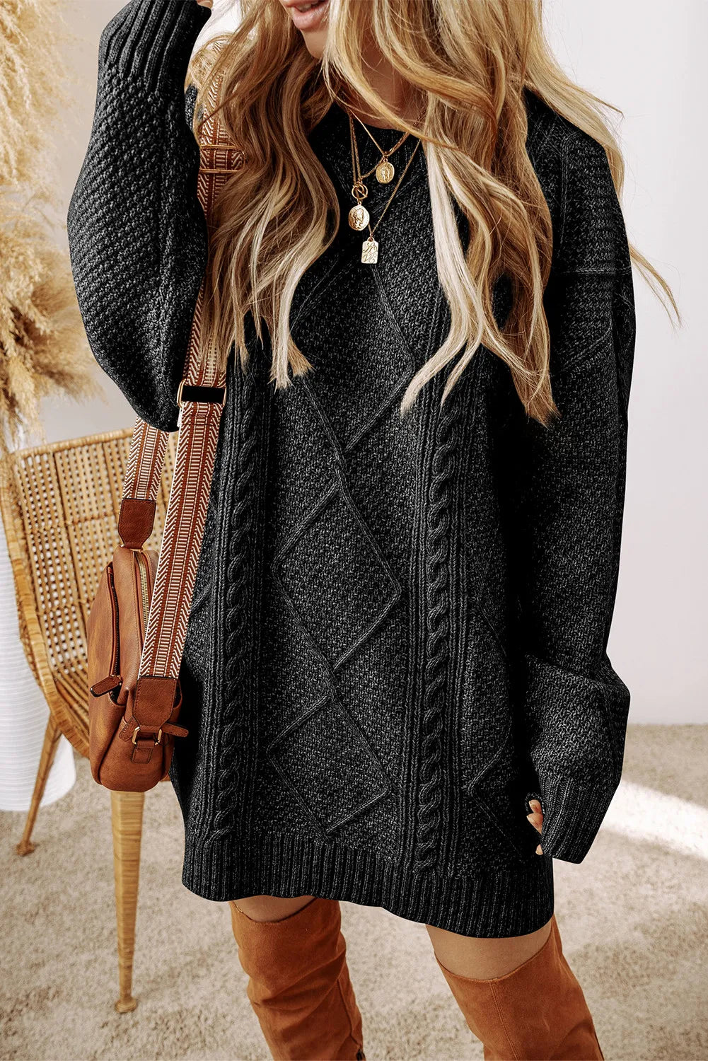 Black cable-knit round-neck sweater dress with long sleeves and diamond cable yoke
