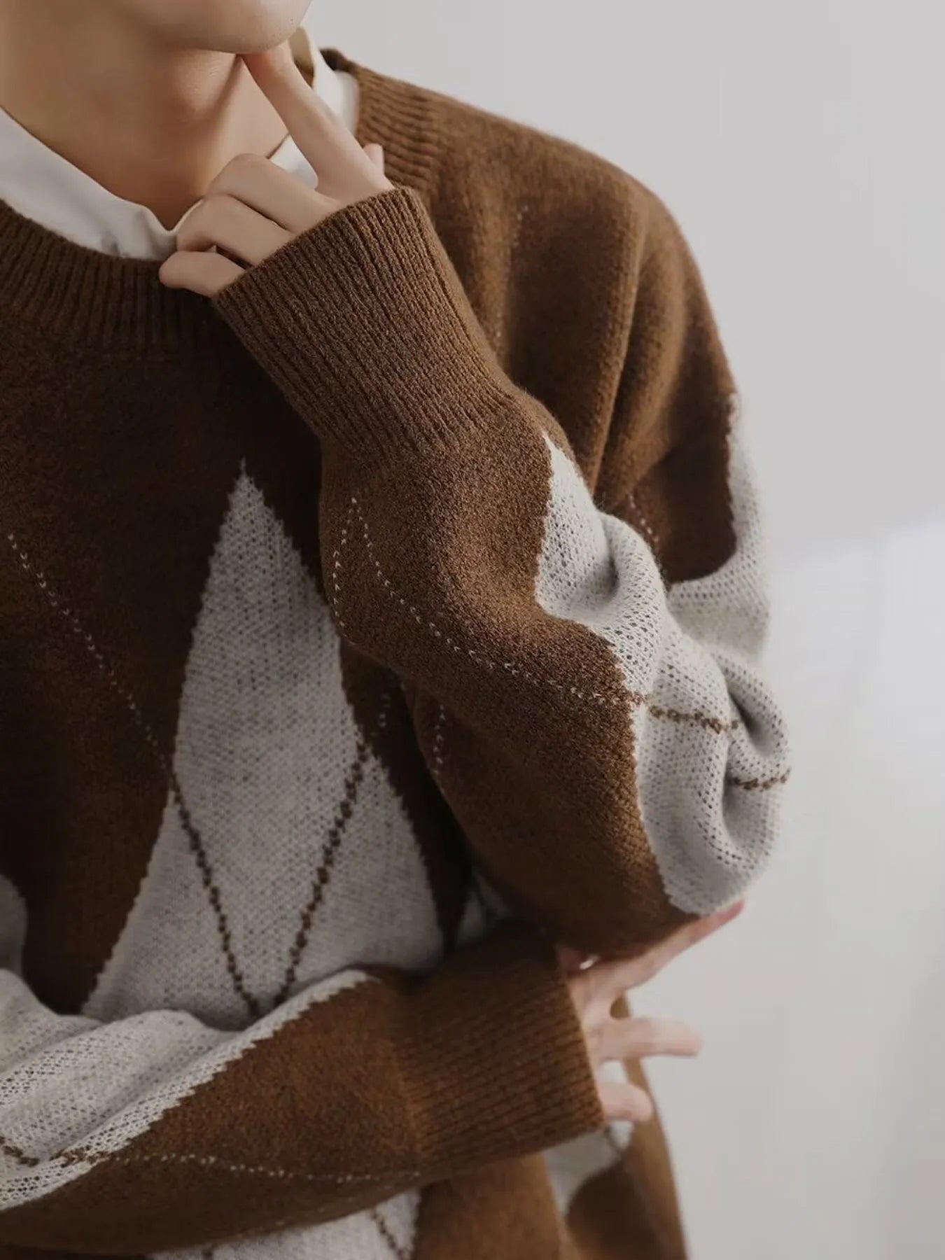 Brown and cream argyle knit sweater sleeve with diamond pattern and ribbed cuff