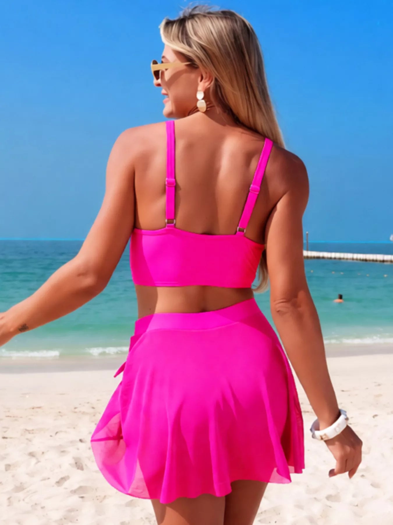 Twist Front Cami and Skort Swim Set by Trendsi in hot pink on model at the beach