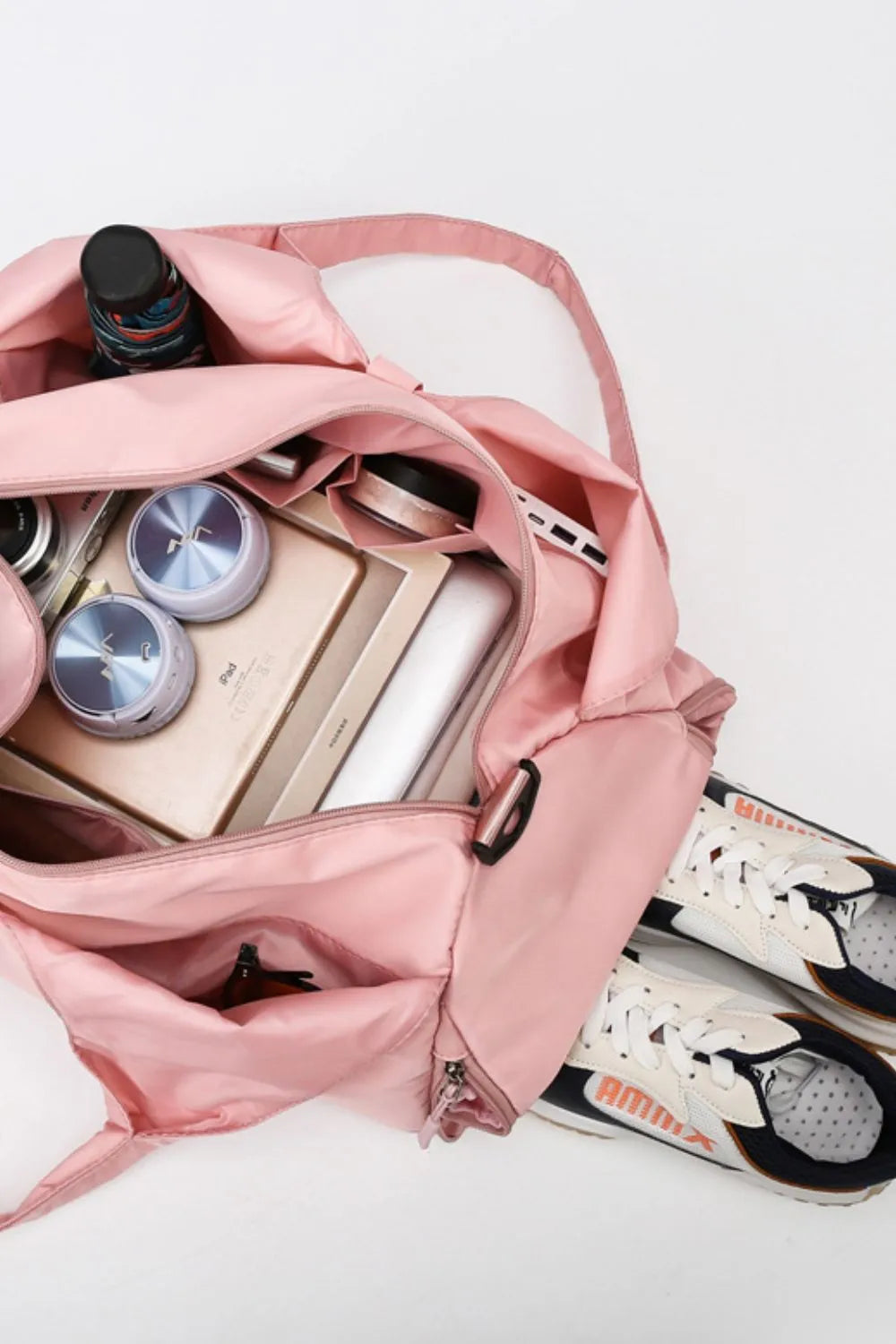 Dusty pink travel tote bag open with interior pockets and zipped compartment.