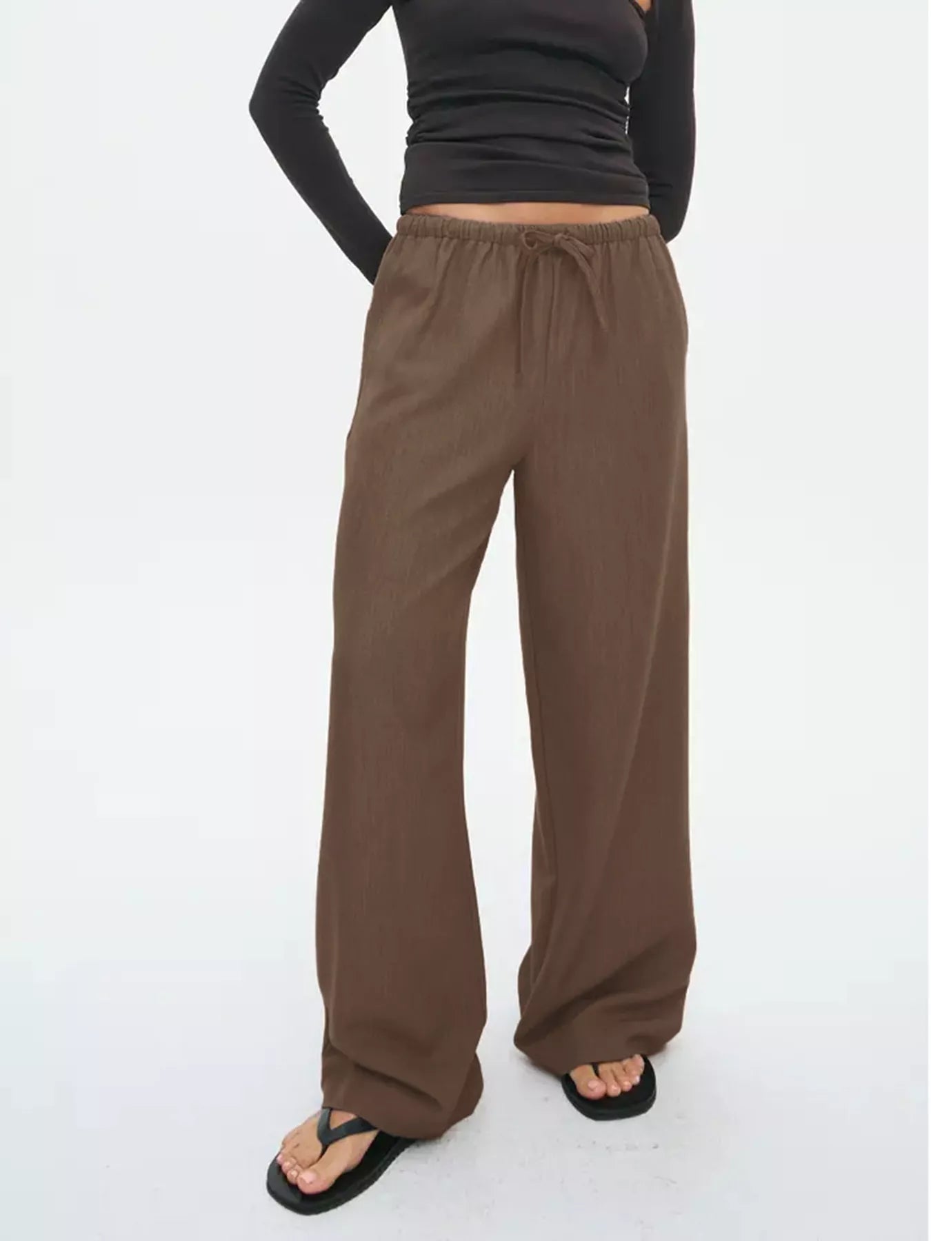 Brown wide-leg drawstring pants with elastic waist, shown from side with full length.
