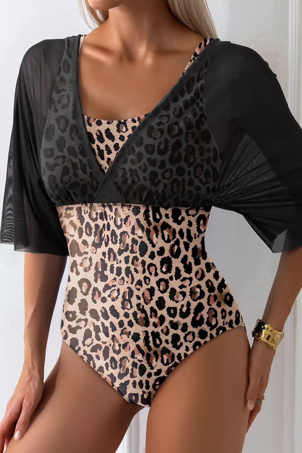 Leopard-print bodycon swimsuit with black mesh half sleeves and V-neck back overlay detail.