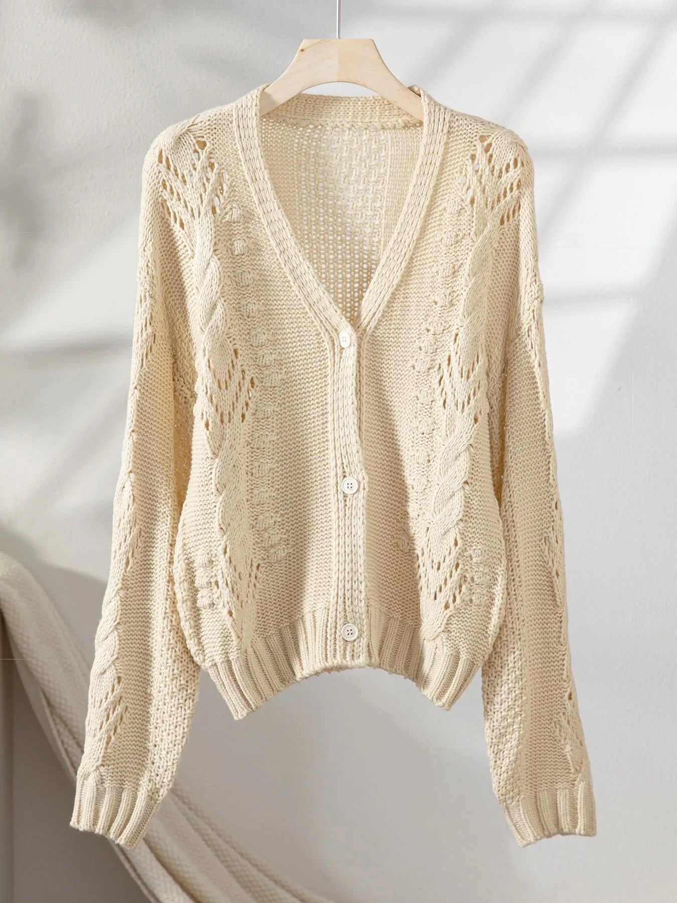 Beige cropped button-up sweater cardigan with cable knit texture and button front