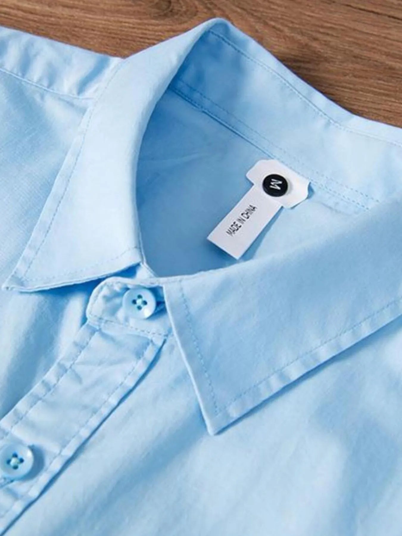 Light blue button-up shirt neckline and collar with inner neck tag