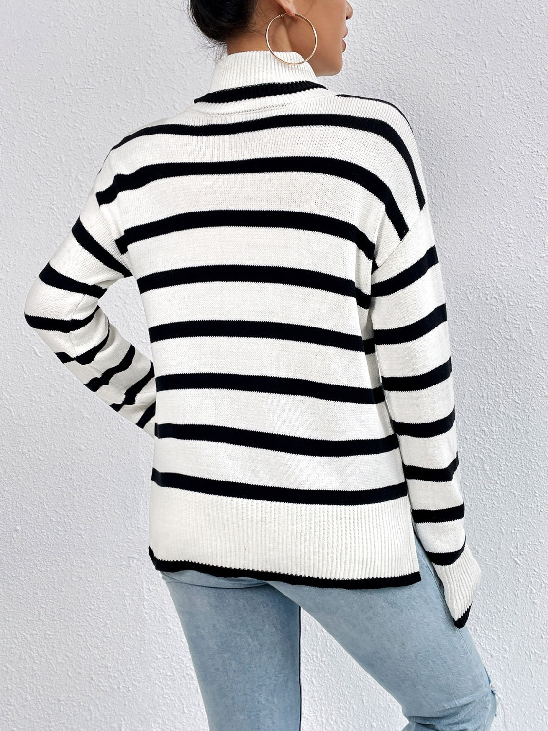 White and black striped turtleneck sweater with ribbed collar and drop-shoulder