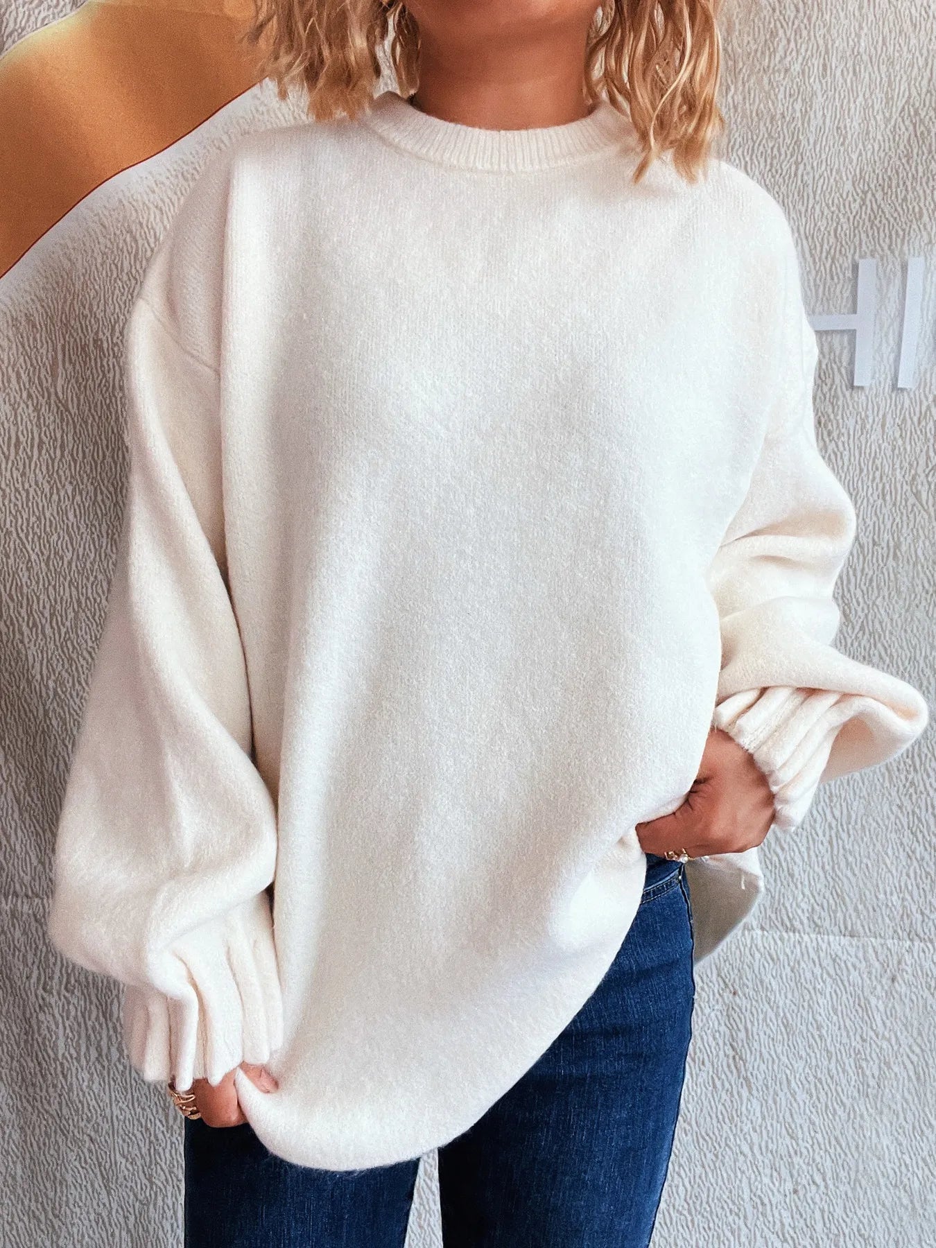 White dropped shoulder sweater with round neckline and ribbed sleeve cuffs