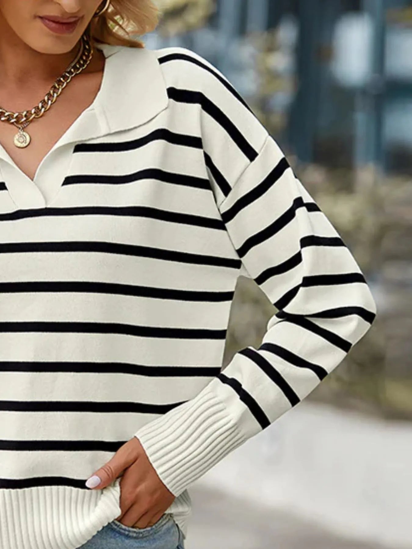 Striped long-sleeve sweater close-up, ribbed cuffs and collar, white with black stripes