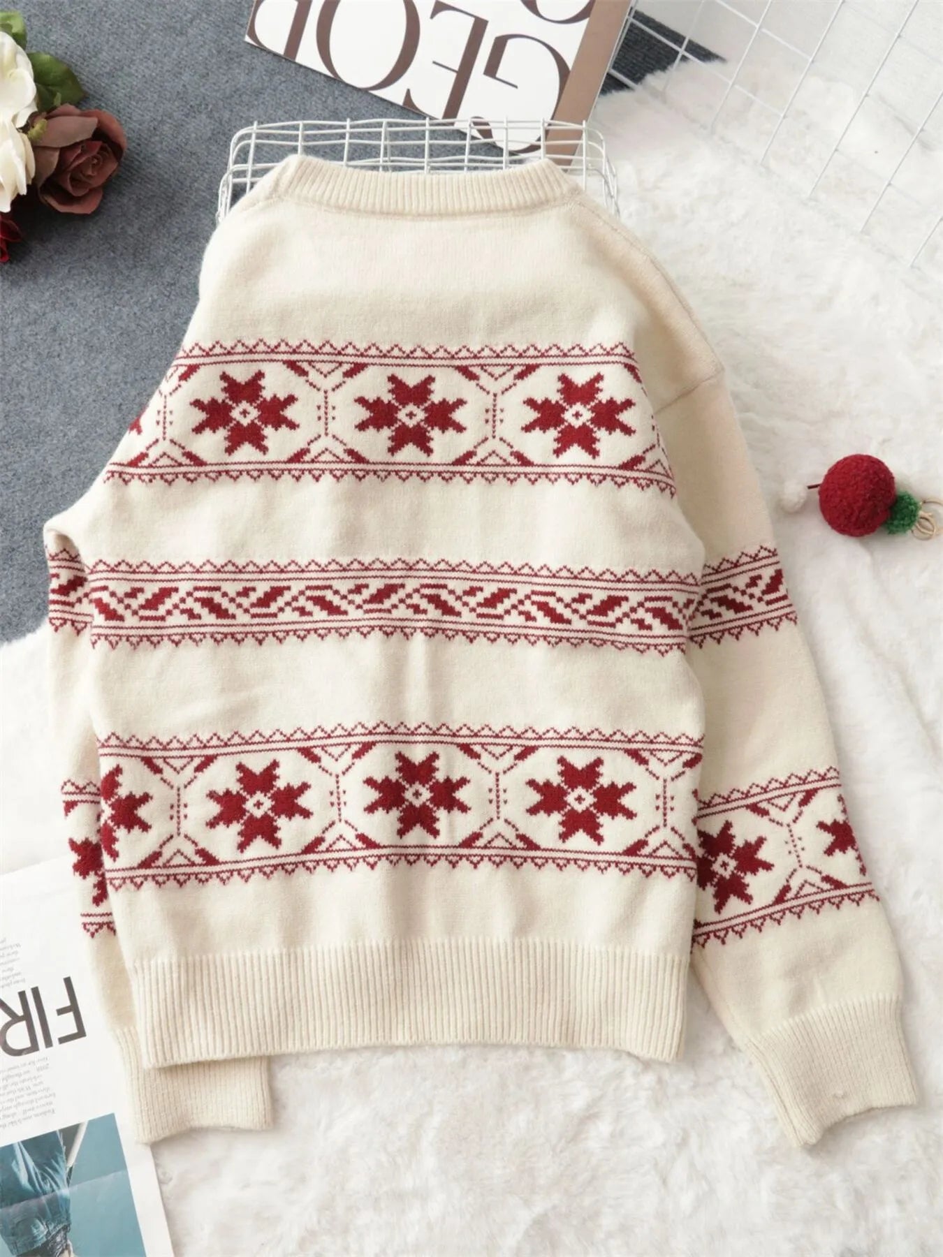 White crewneck knit sweater with red snowflake Fair Isle stripe pattern on front