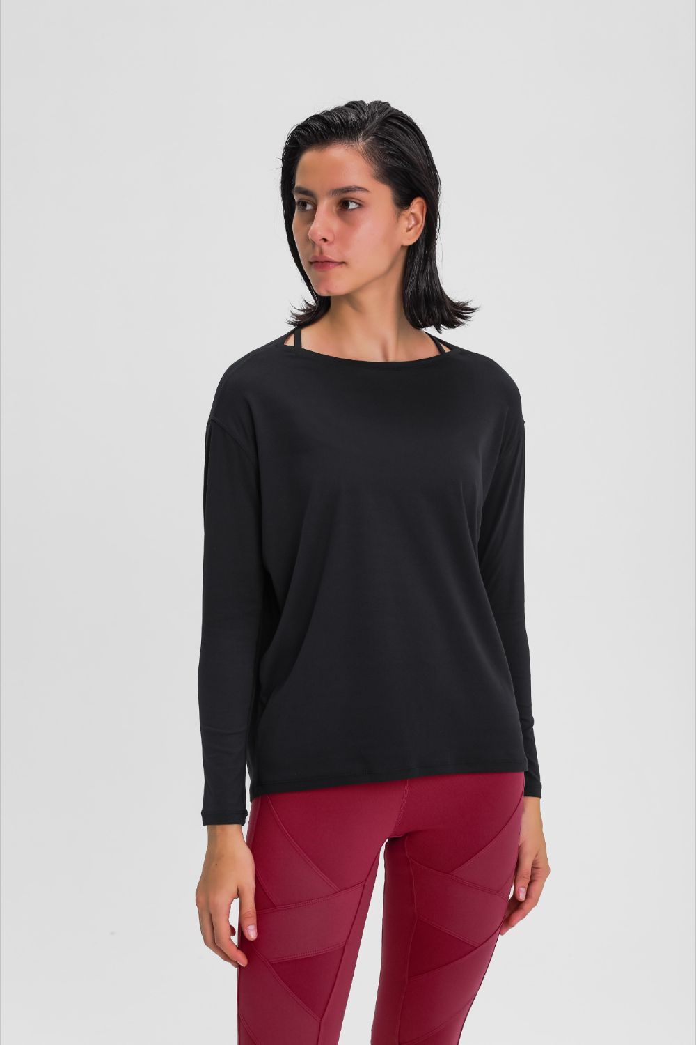 Loose fit active top in black, front view with long sleeves and smooth drape.