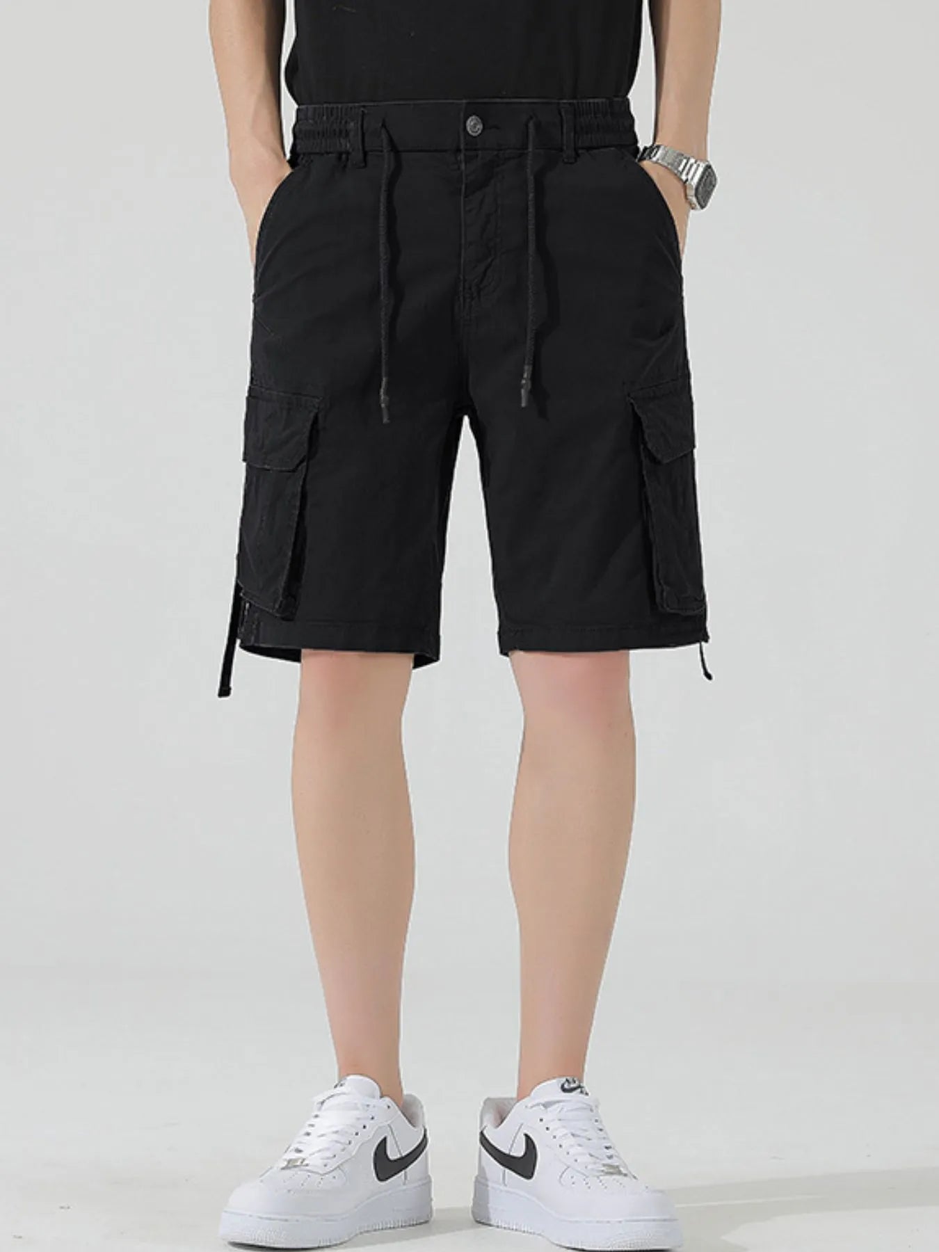 Men's black drawstring cargo shorts with front and side flap pockets
