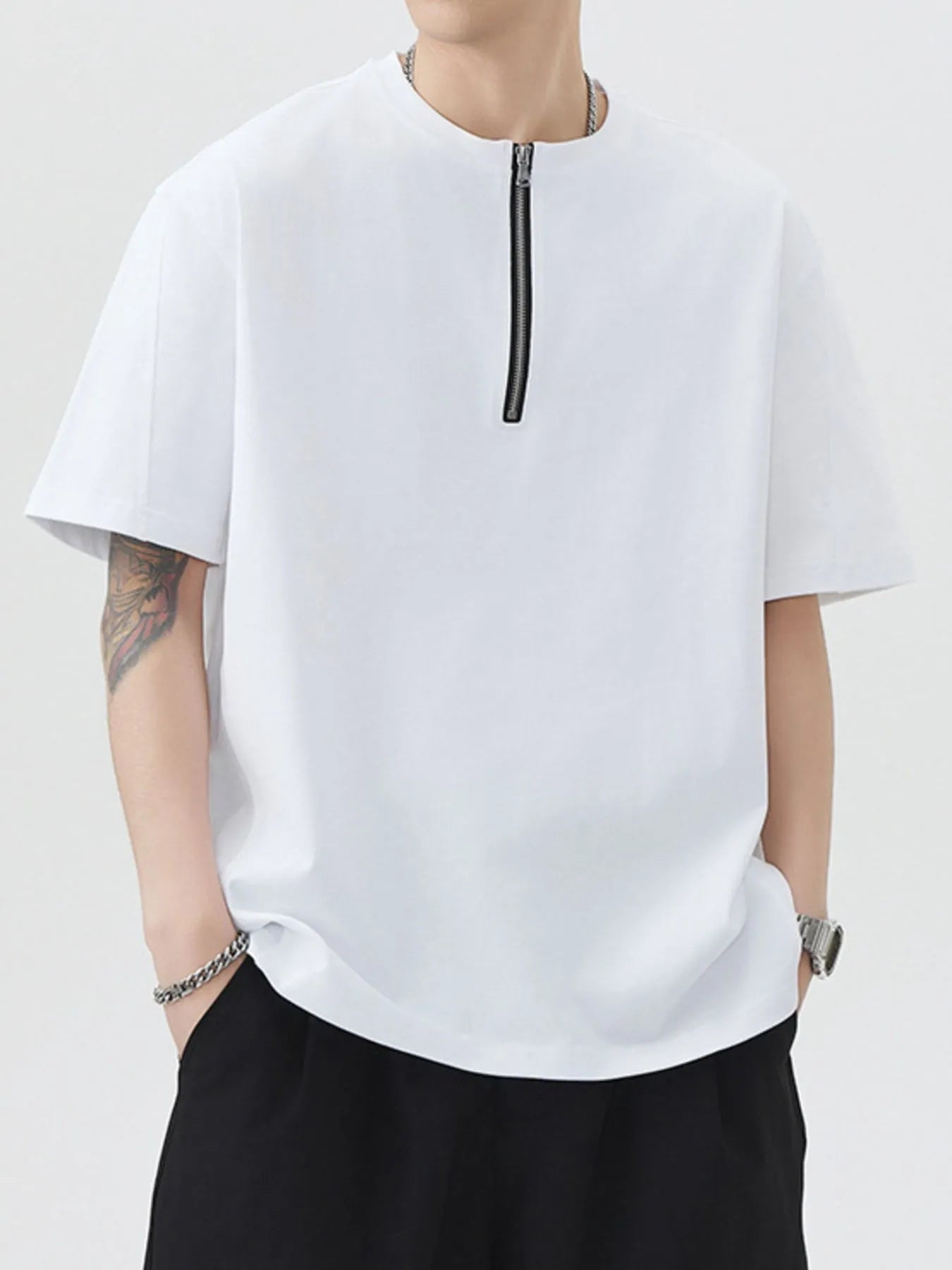 White oversized half-zip T-shirt, front view with central zipper and short sleeves