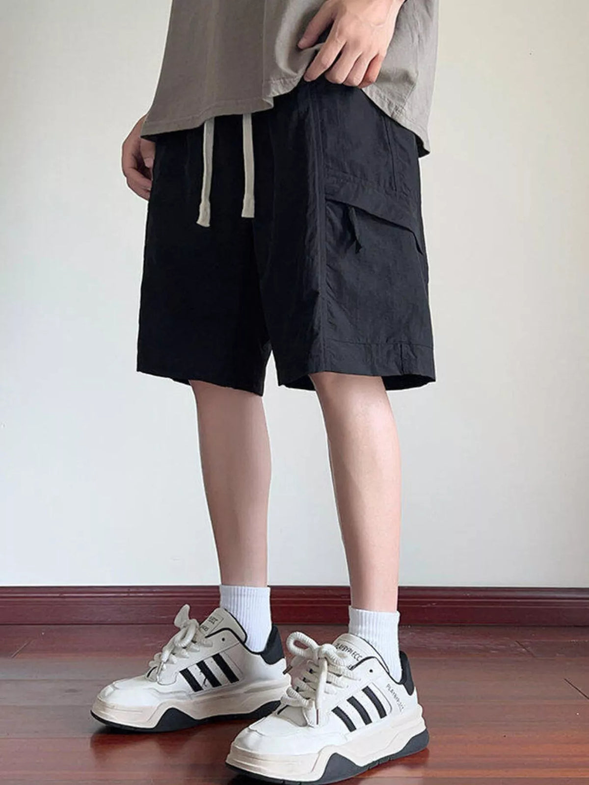 Black cargo shorts with drawstring waist and oversized side pocket flaps
