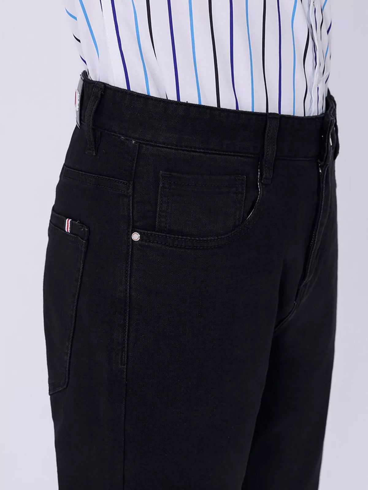 Black jeans close-up with front pocket, coin pocket, and belt loop detailing