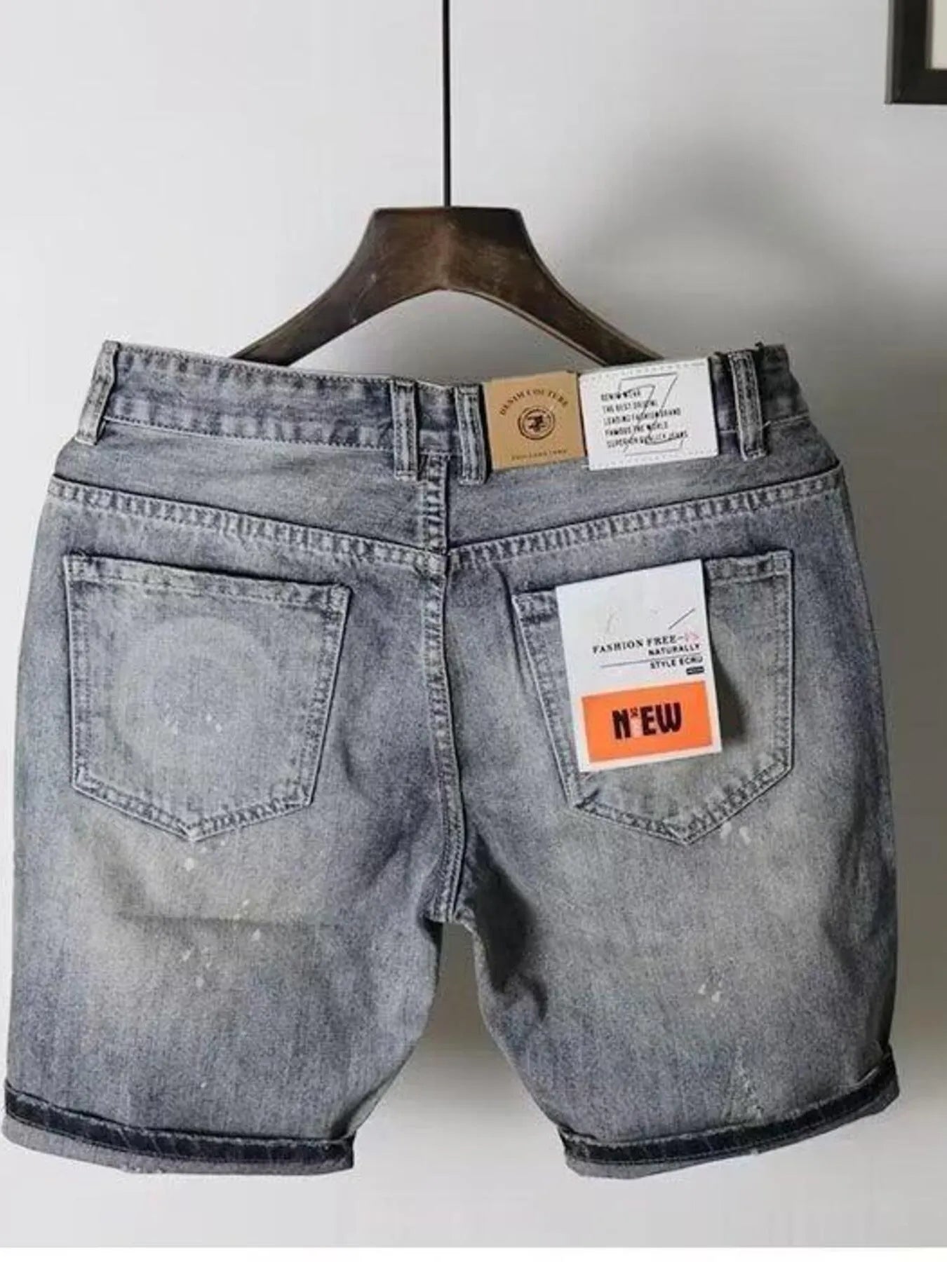 Light gray distressed denim shorts with two back pockets and waistband label tags