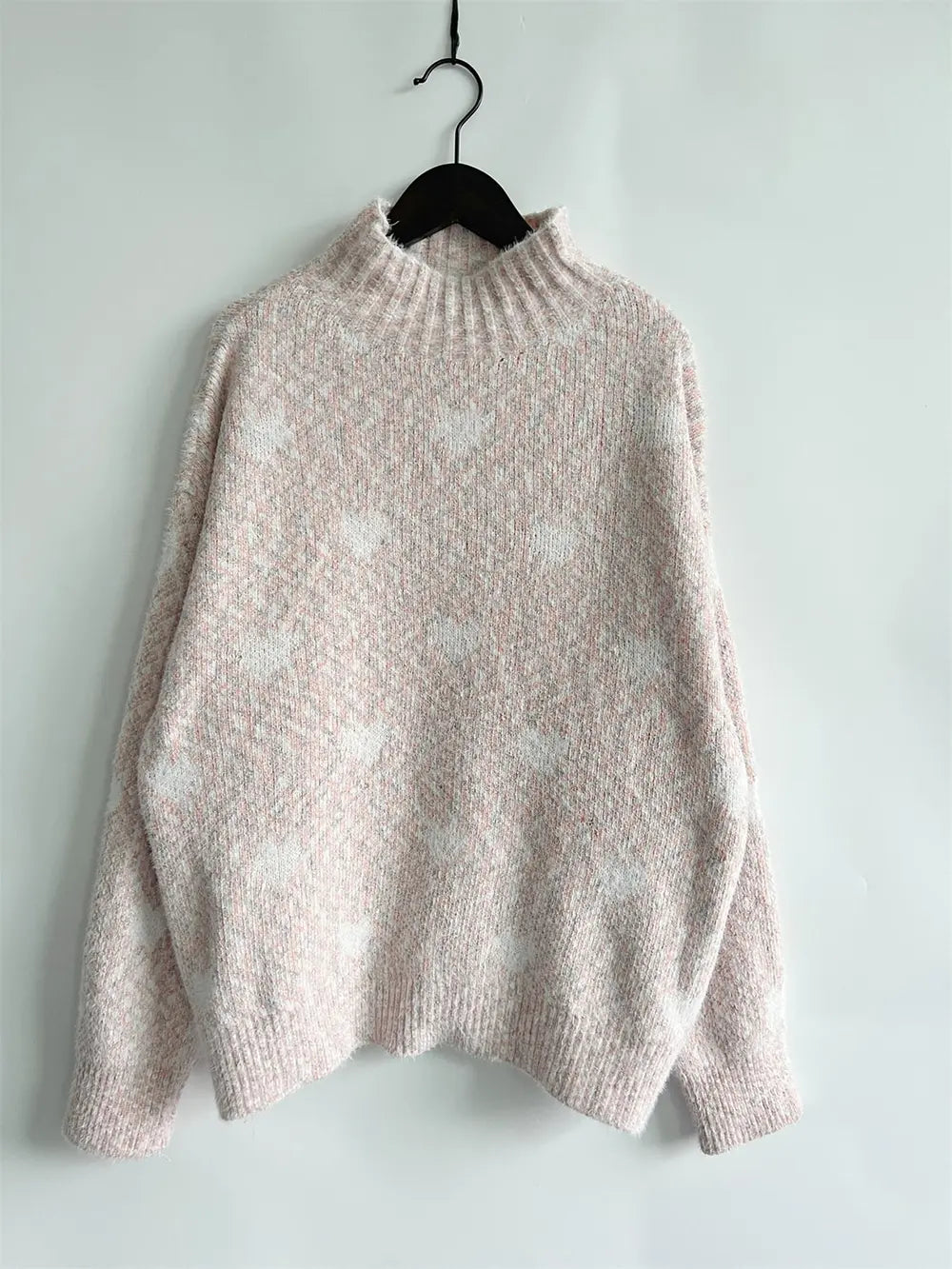 Light pink heathered knit turtleneck sweater with drop shoulders and ribbed cuffs