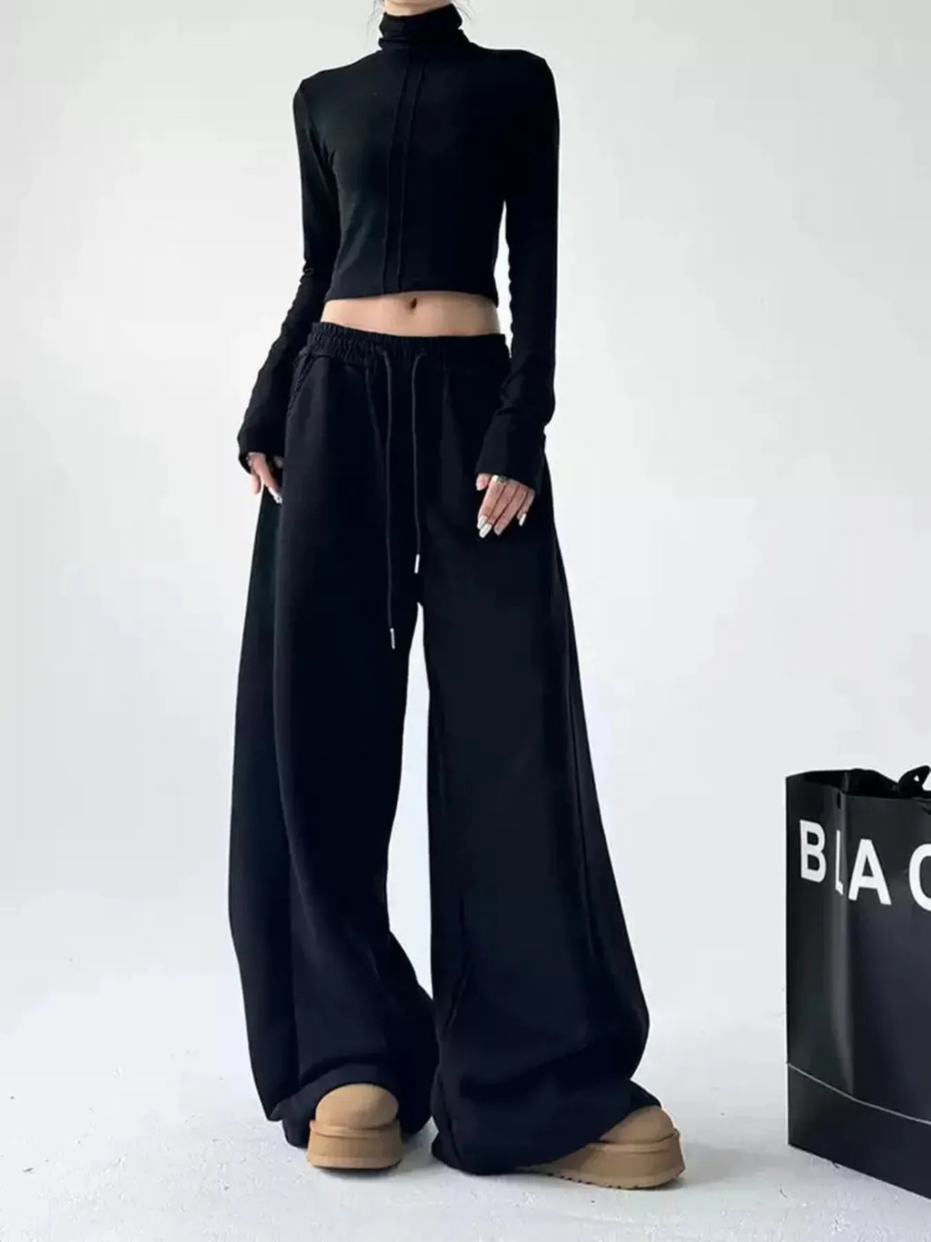 Black oversized wide-leg drawstring pants with gathered waistband and side pockets