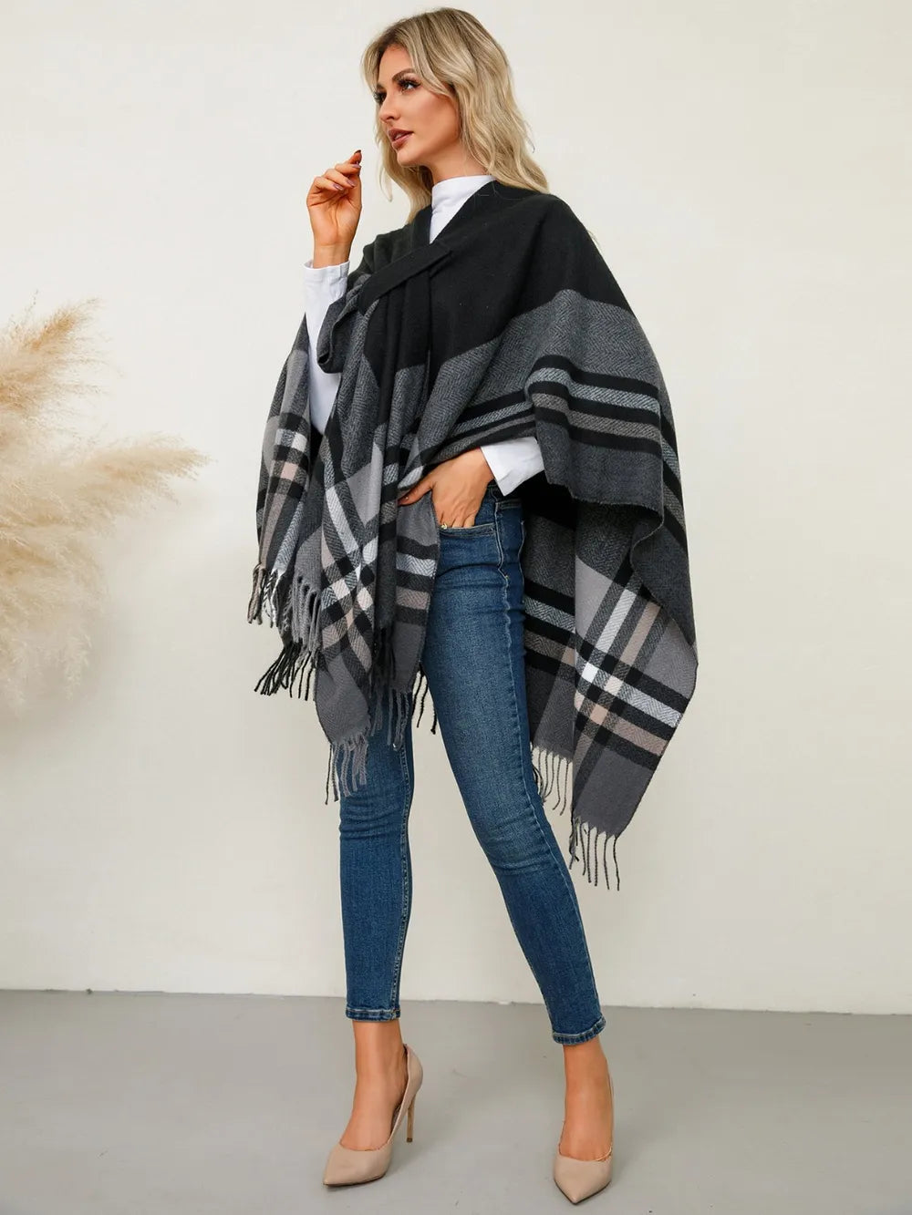 Fringe plaid poncho with black base, gray check stripes, and long side fringe