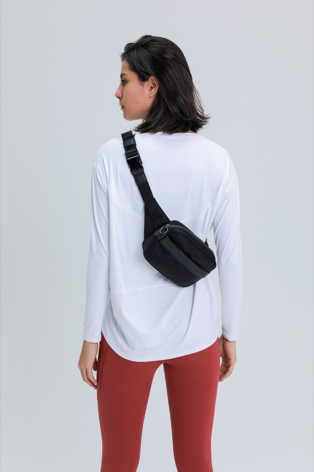 Loose fit active top in white, back view with rounded neckline and long sleeves.