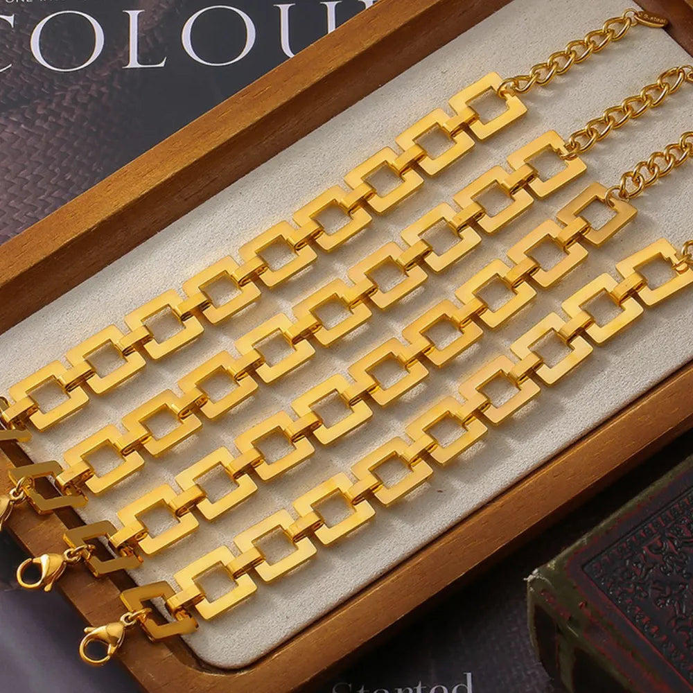 Gold hollow square link chain bracelet laid flat with matching chain extension