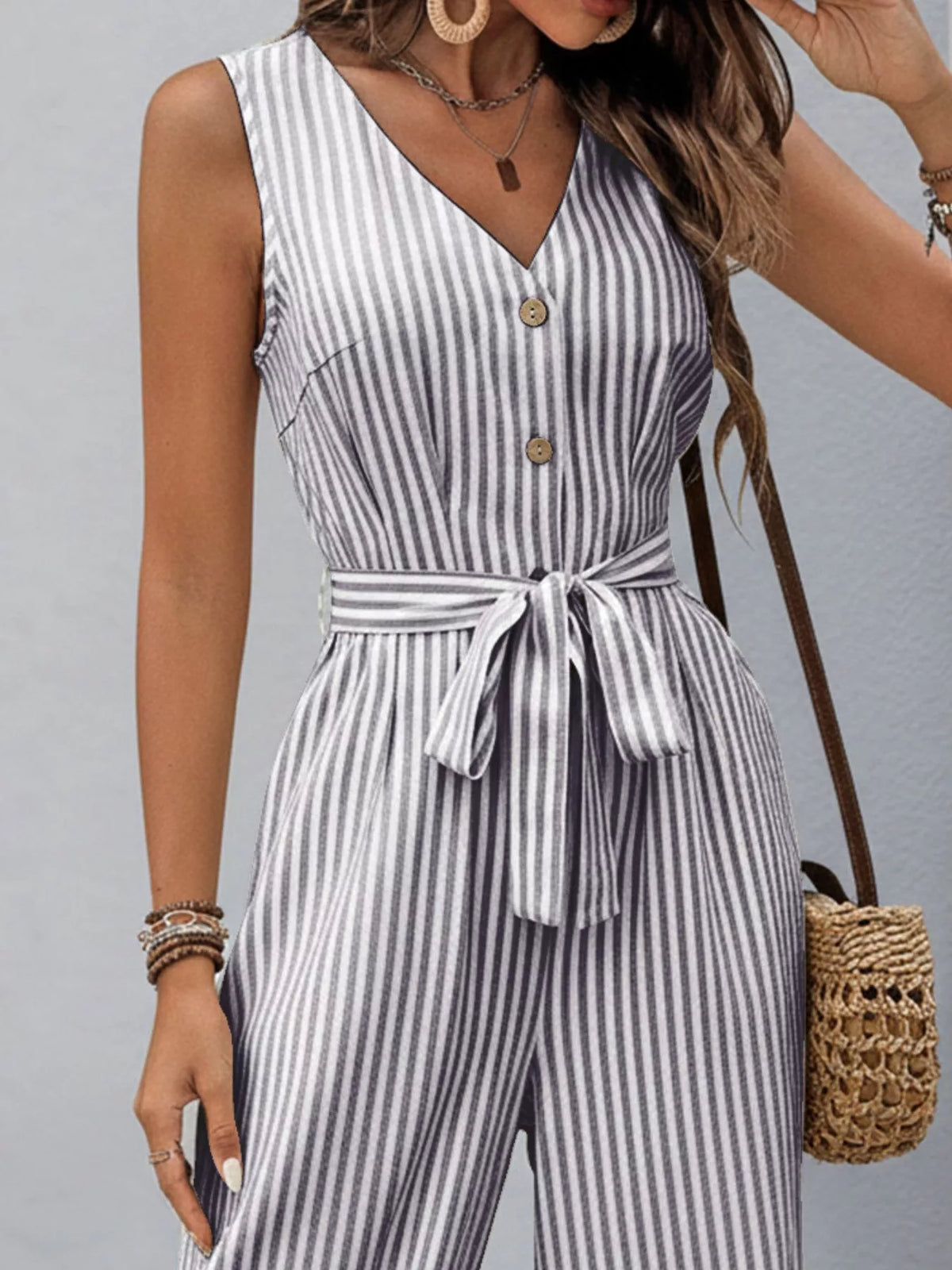 Blue-and-white striped sleeveless V-neck jumpsuit with button front and waist tie
