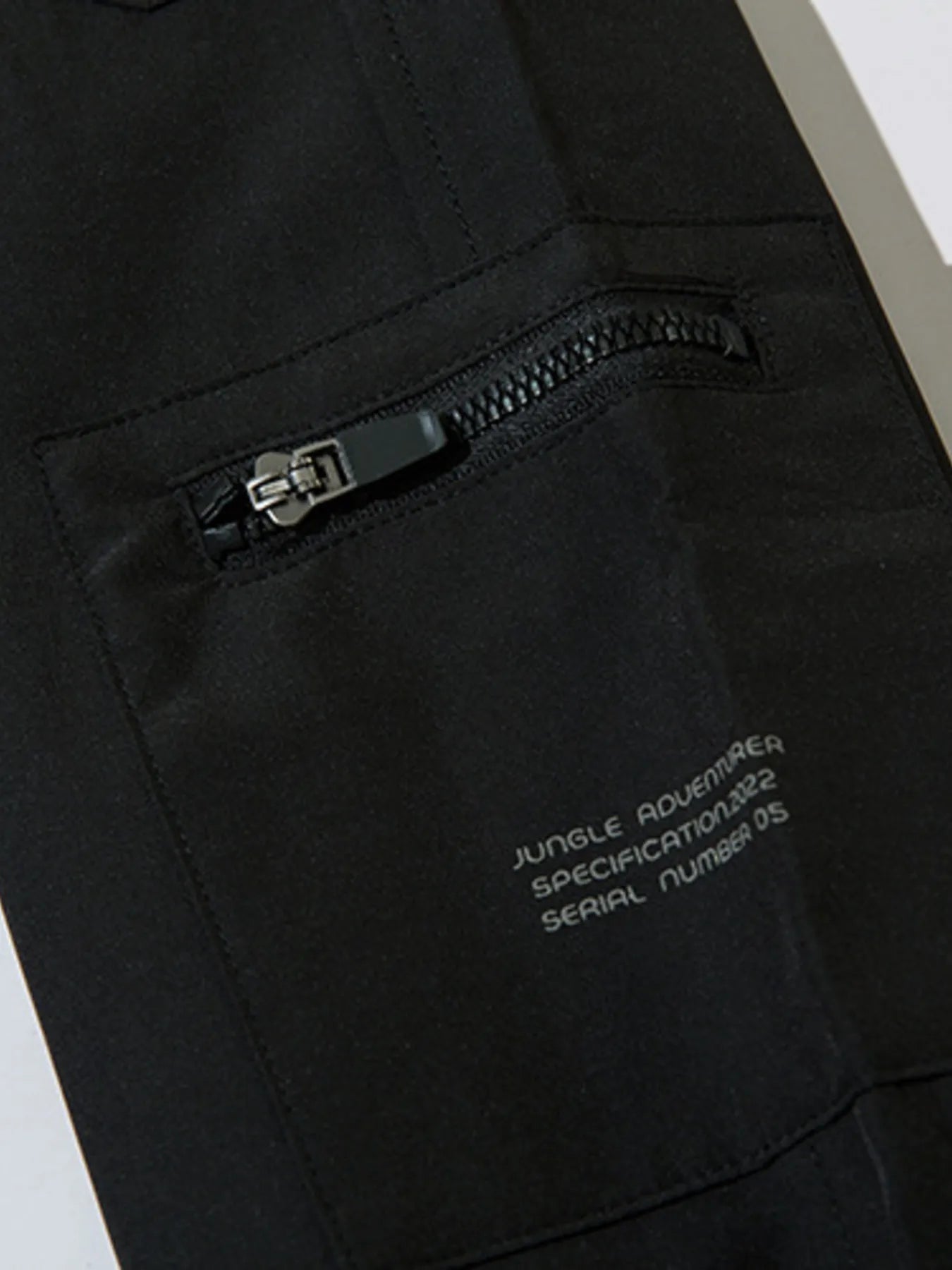 Black cargo joggers with zippered cargo pocket and small printed logo text