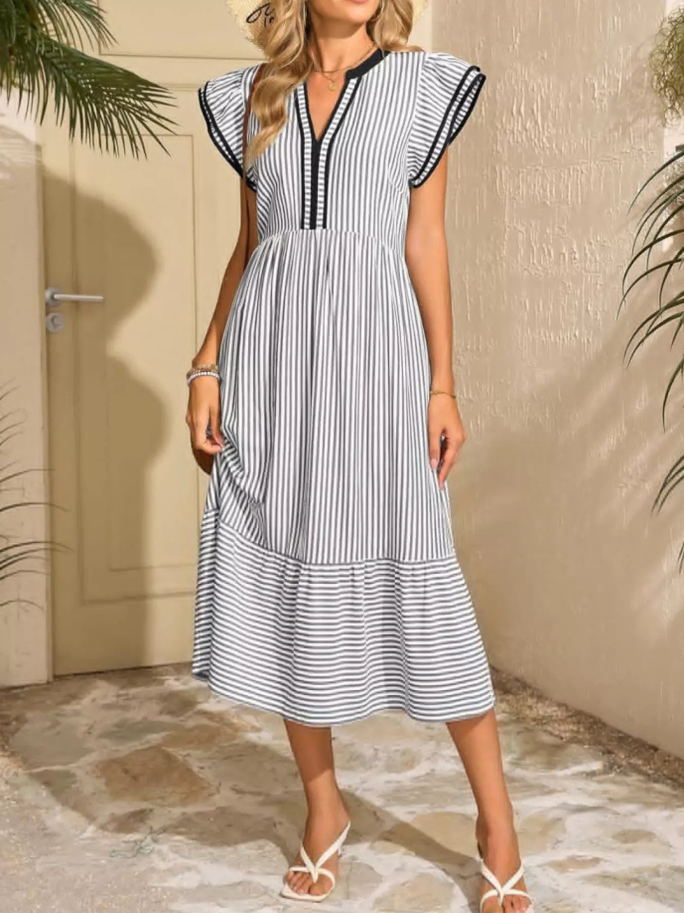 Black and white striped midi dress with ruffle cap sleeves and V-neck; tiered hem