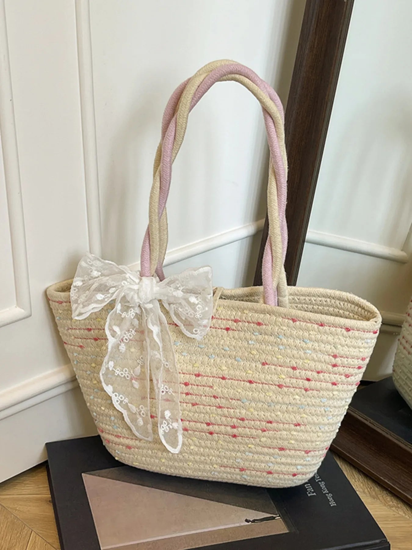 Woven straw shoulder bag with white lace bow and pastel pink handles