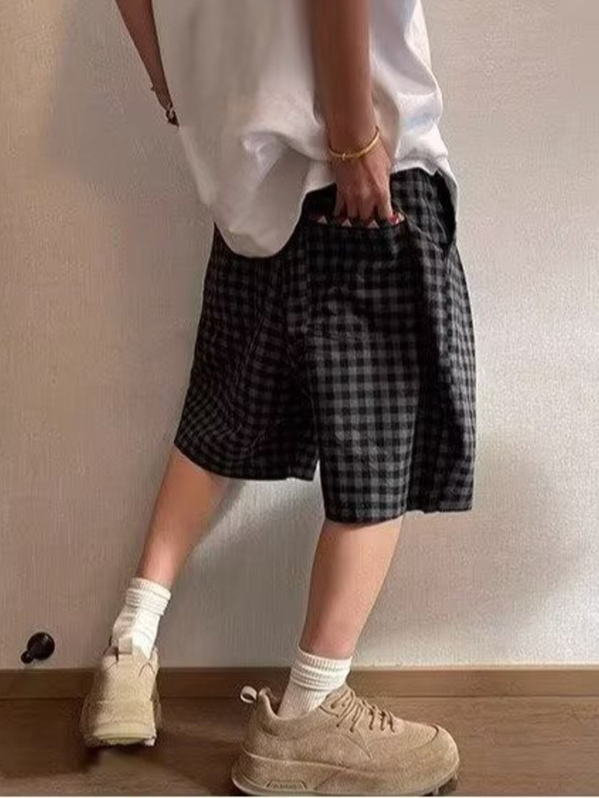 Dark plaid drawstring shorts with elastic waistband and multicolor tie strings, side view