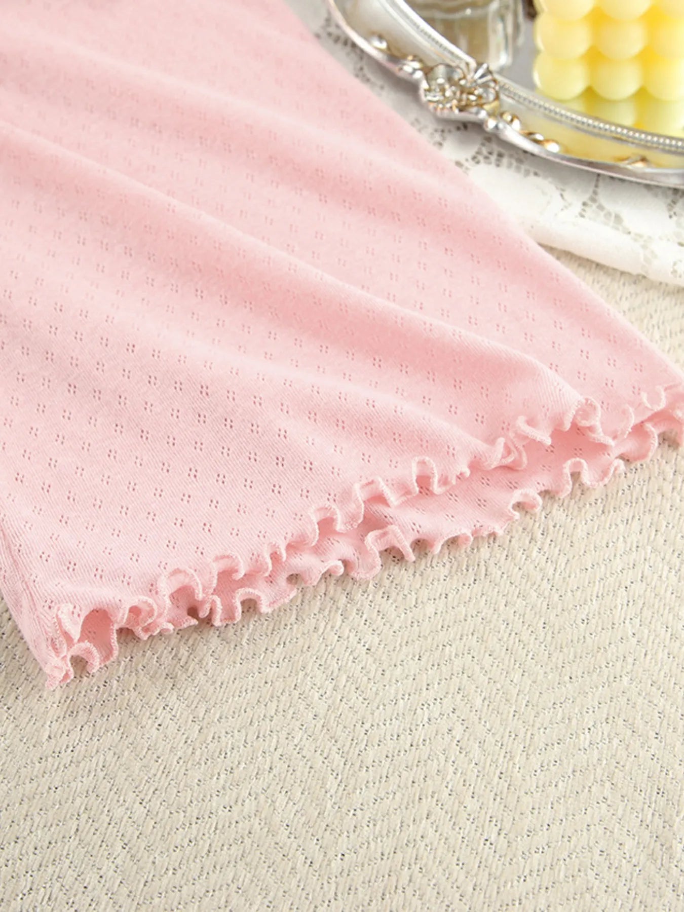 Dusty pink nightgown hem with scalloped ruffle trim and textured fabric