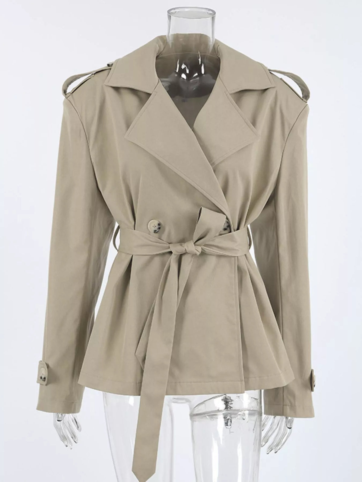 Khaki double-breasted belted trench coat on mannequin with notch lapels and gold buttons
