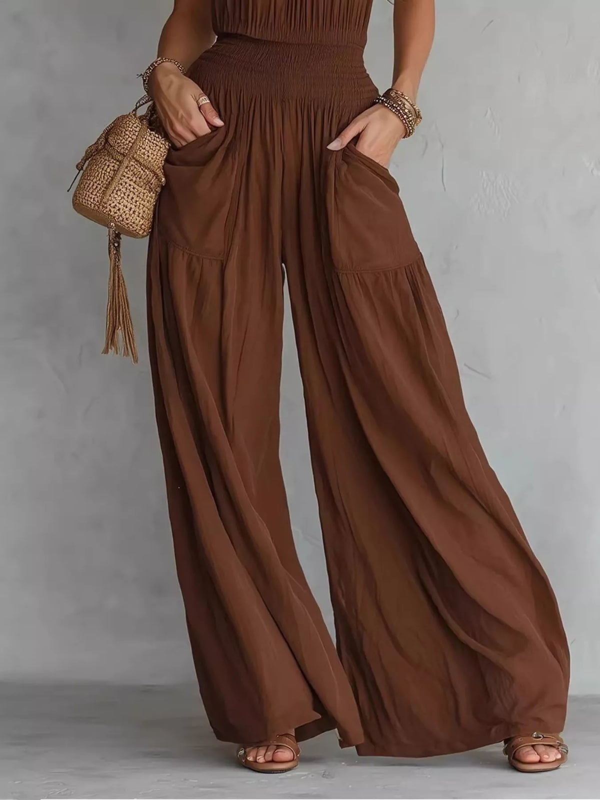 Brown smocked wide-leg jumpsuit with front pockets and draped pleats