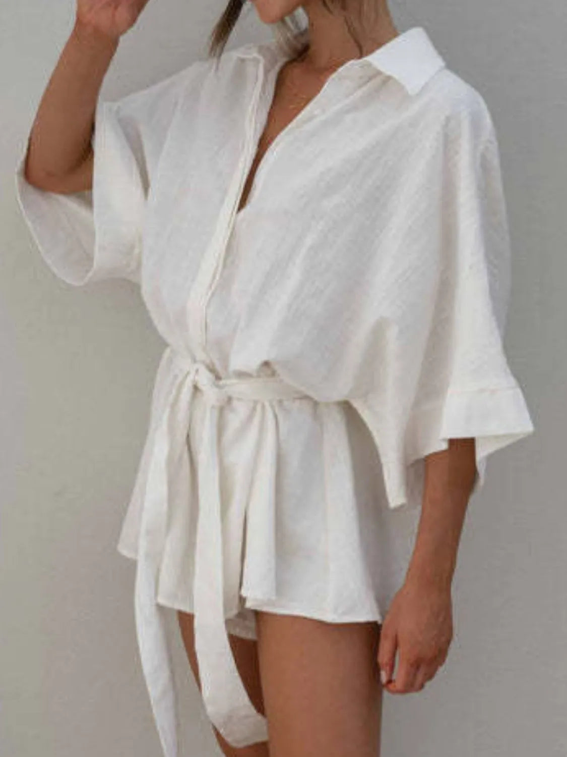 White collared half-sleeve romper with button front and waist tie