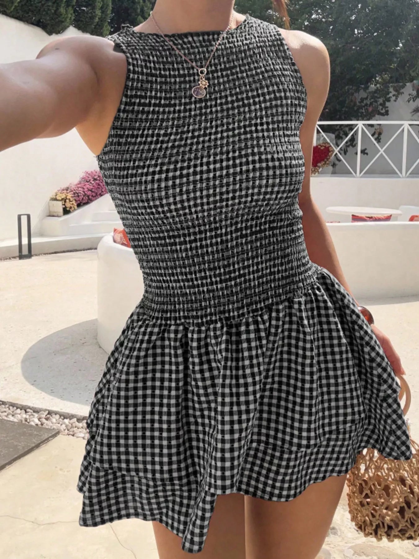 Gingham smocked mini dress; sleeveless, black-and-white check with ruffled hem