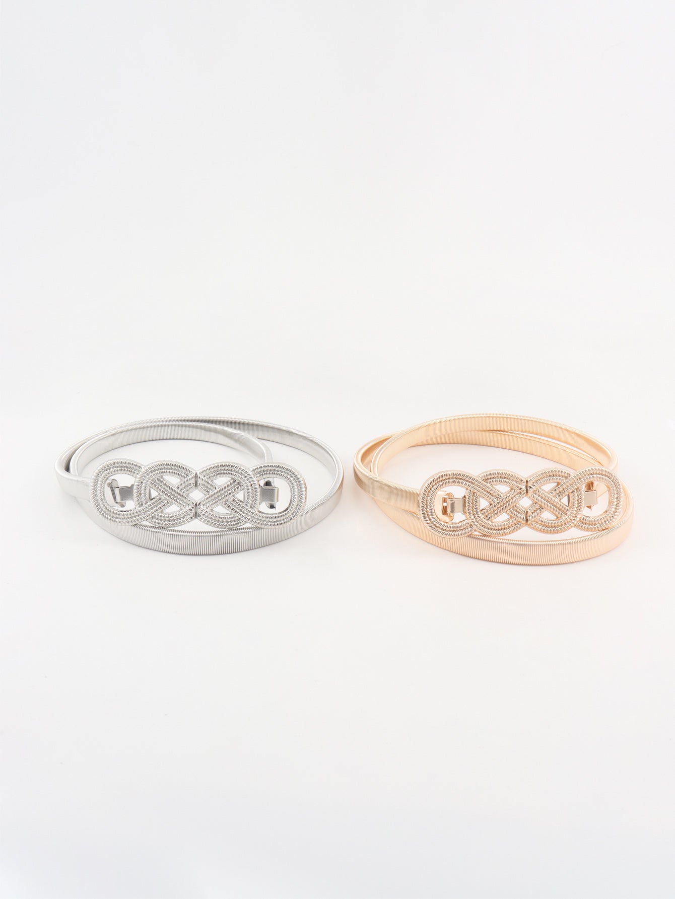 Silver and blush pink knot buckle belts side by side, braided centers