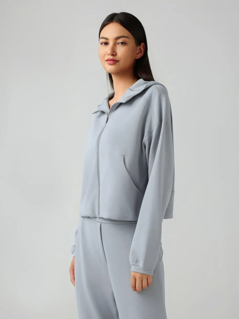 Light blue zip-up active hoodie with hood, front zipper, and elastic cuffs, side profile