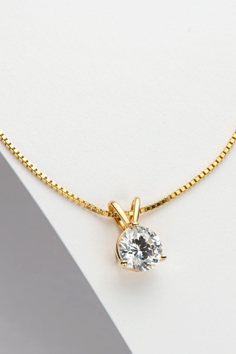 Gold-tone pendant necklace with small round moissanite stone on link chain