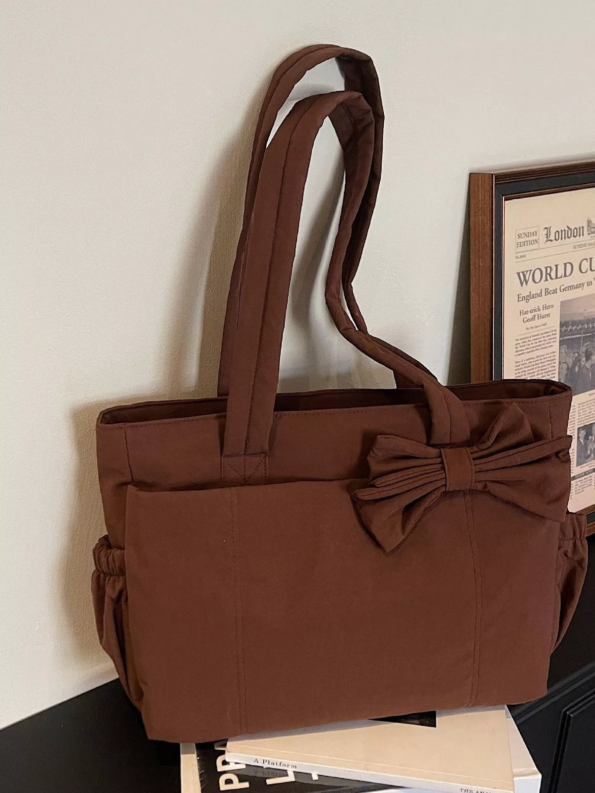 Brown medium casual tote bag with front bow accent and wide carrying handles
