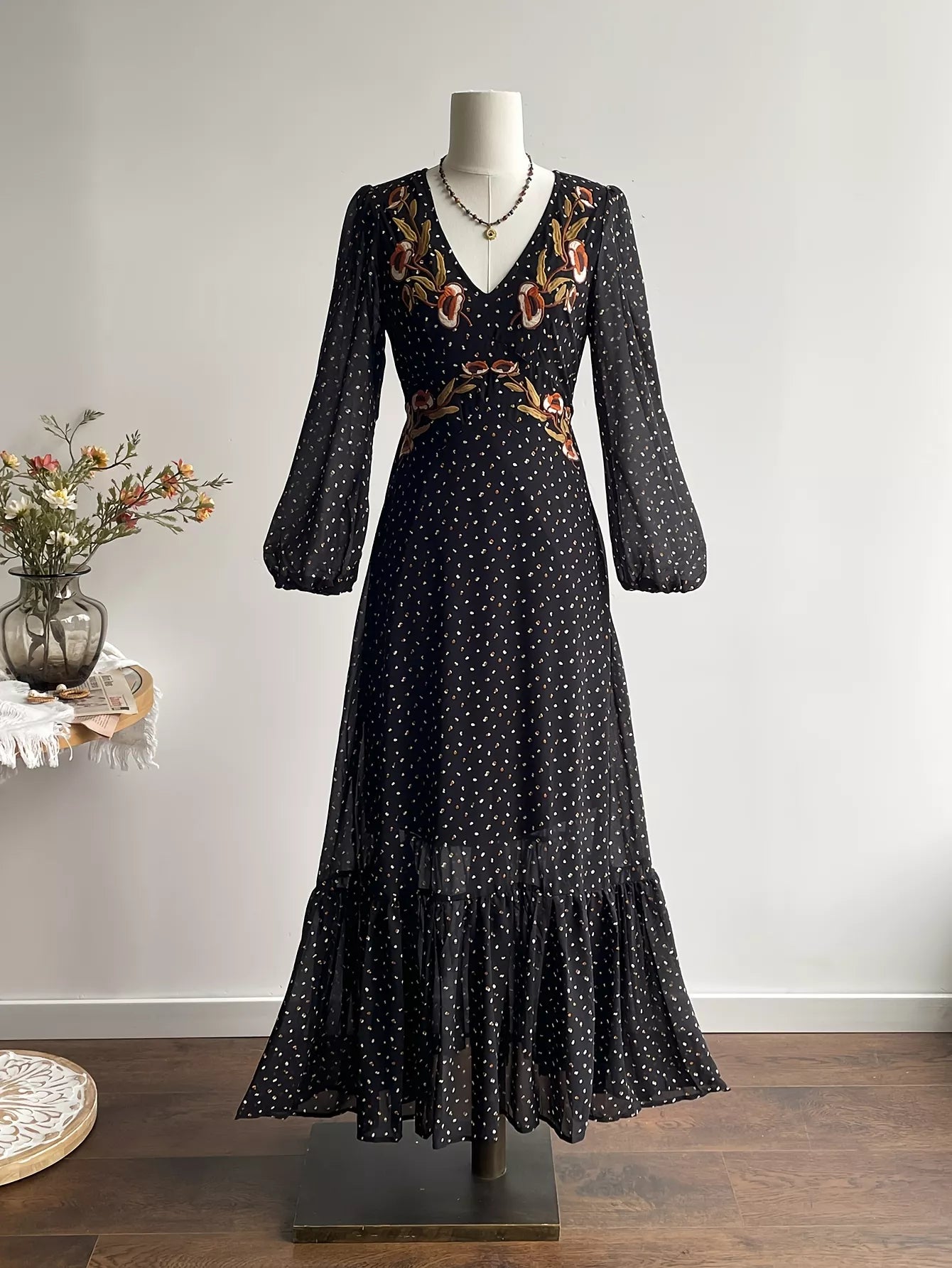 Black polka dot maxi dress on mannequin, long sleeves and gathered tiered skirt