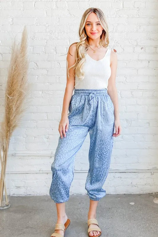 Pale blue satin leopard print joggers with elastic waist and slouchy ankle cuffs
