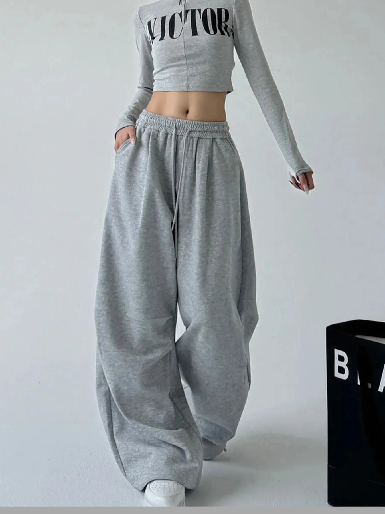 Dark gray oversized wide-leg drawstring pants with elastic waistband and loose wide legs