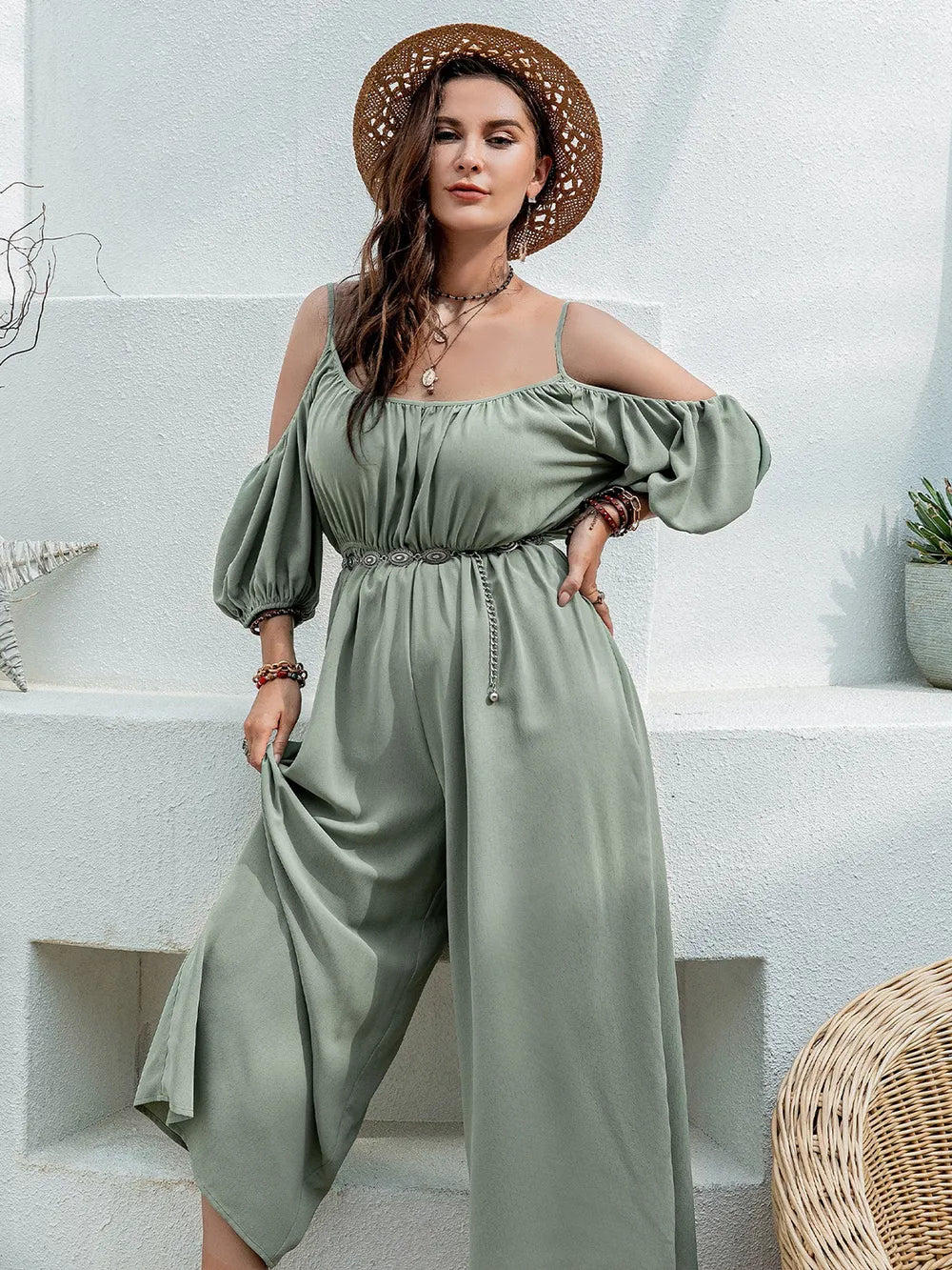 Sage green jumpsuit with spaghetti straps, gathered neckline, flowy wide legs and draped sleeves